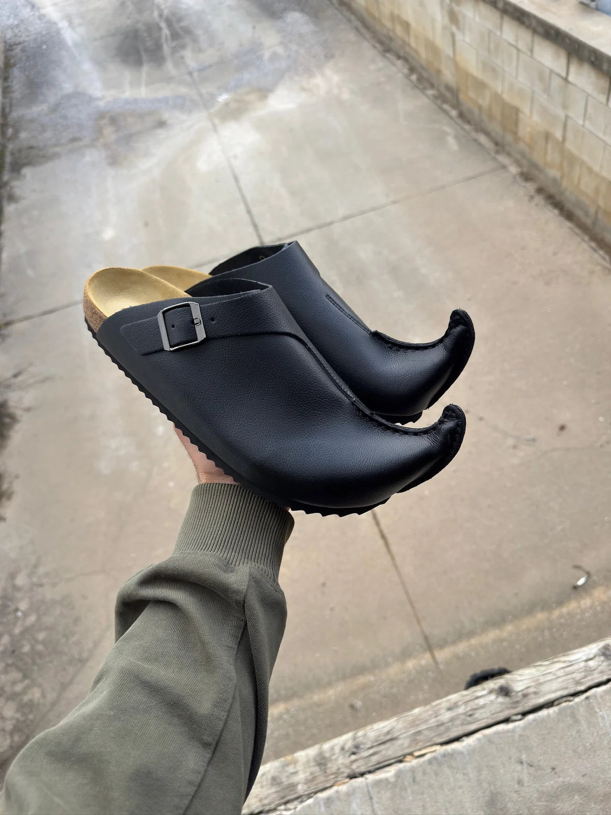 Black Elfenstock clogs with curled toes and silver buckles
