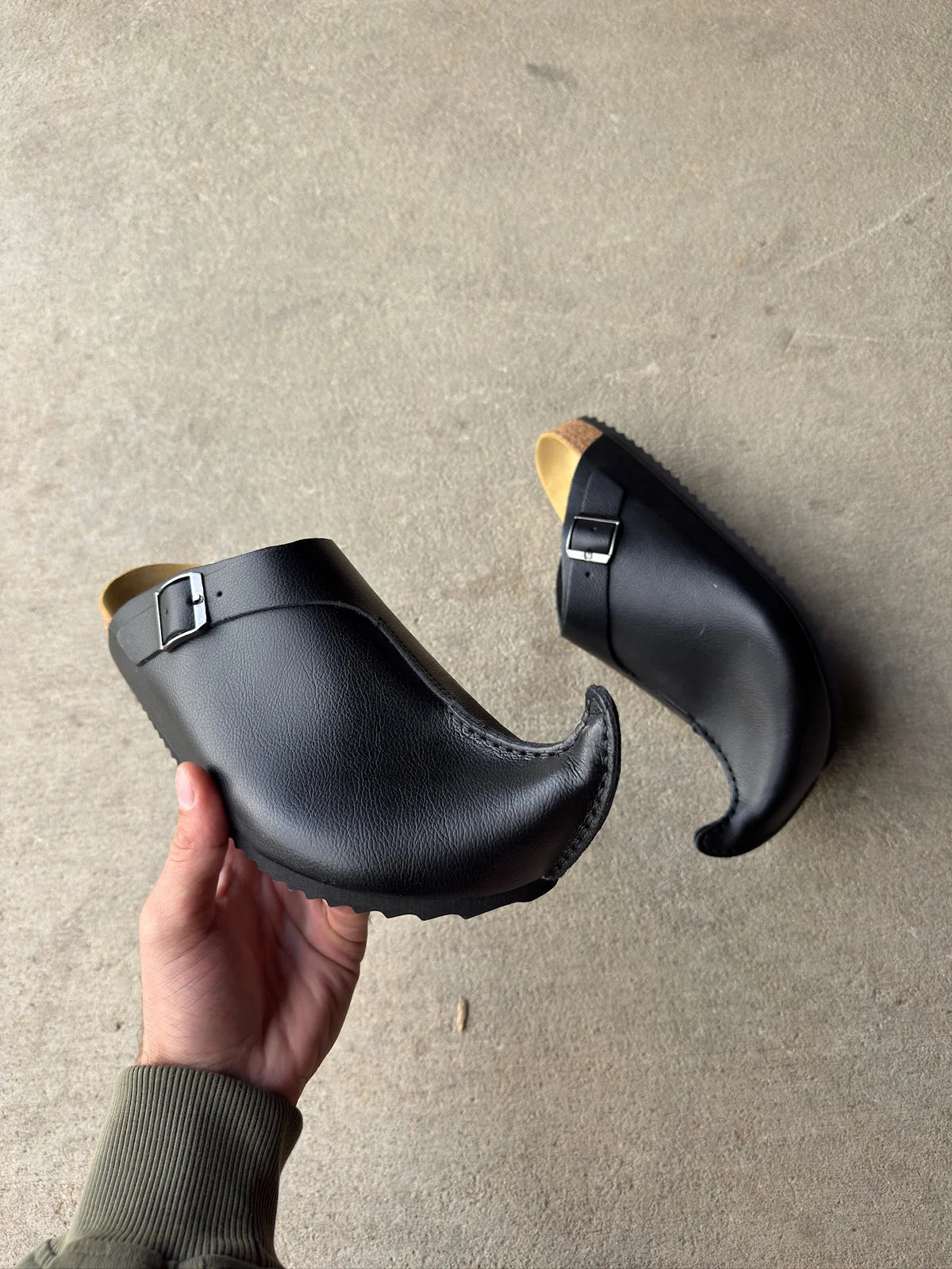 Elfenstock black clogs showing curled toe silhouette and cork midsole